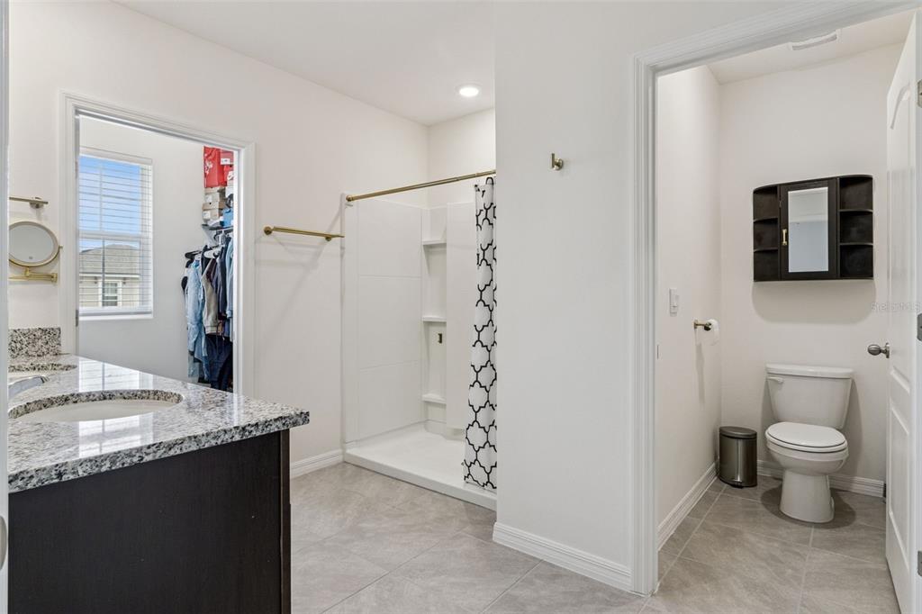 3914 Resting Robin Avenue Bartow, FL 33830 - Photo 21 of 45 a bathroom with a granite countertop sink a toilet a shower and a mirror