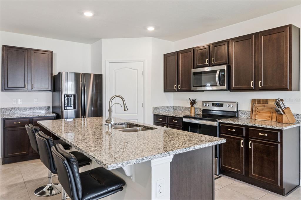 3914 Resting Robin Avenue Bartow, FL 33830 - Photo 8 of 45 a kitchen with granite countertop stainless steel appliances and wooden cabinets