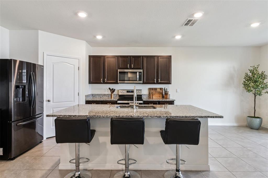 3914 Resting Robin Avenue Bartow, FL 33830 - Photo 9 of 45 a kitchen with stainless steel appliances granite countertop a refrigerator and a stove top oven