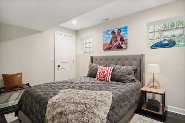 a bedroom with a large bed and a painting on the wall