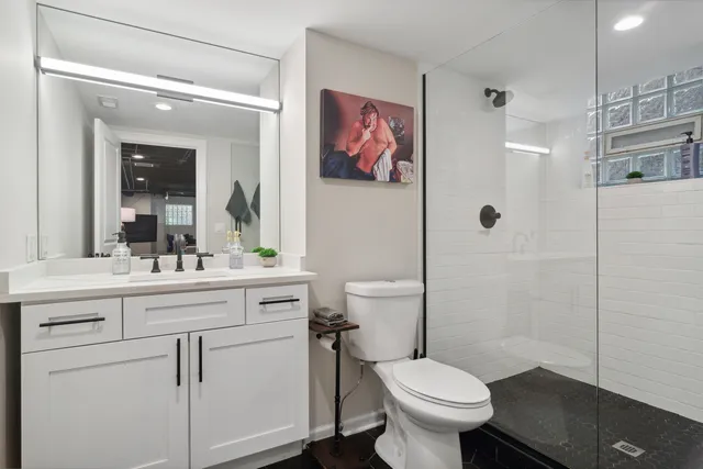 a bathroom with a toilet sink vanity and mirror