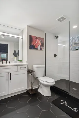 a bathroom with a toilet a sink and mirror