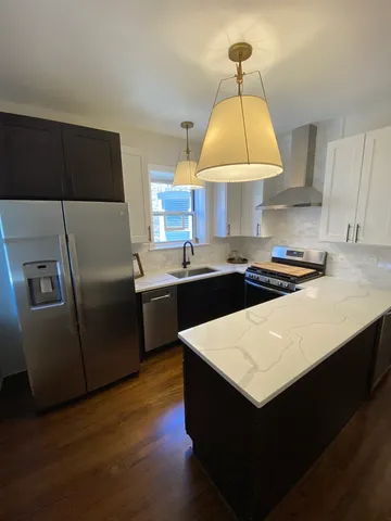 a kitchen with stainless steel appliances a stove a sink a refrigerator and a microwave