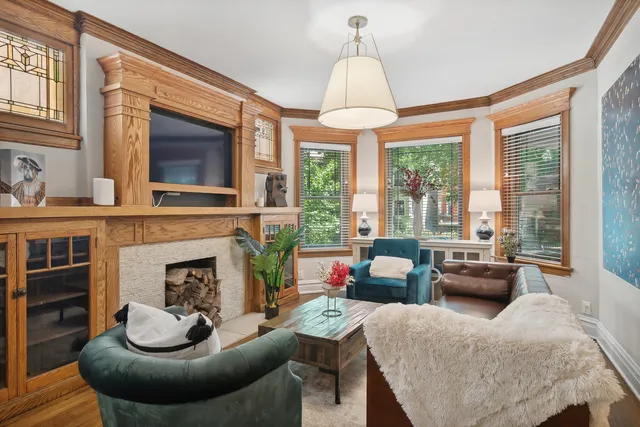 a living room with furniture a fireplace and a large window