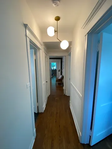 a view of a hallway with wooden floor and staircase