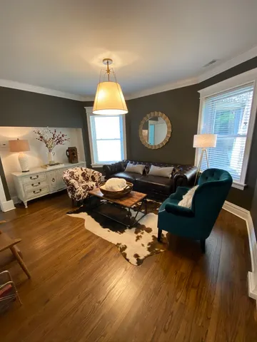 a living room with furniture and a wooden floor