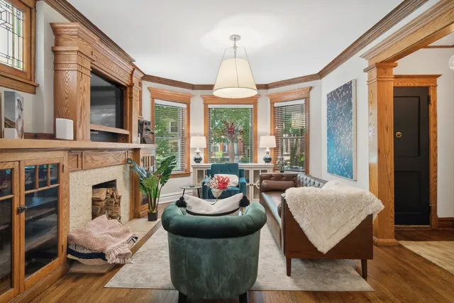 a living room with furniture a fireplace and a large window