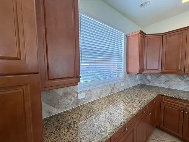 a kitchen with granite countertop cabinets and white appliances
