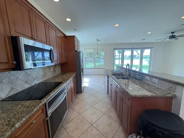 a kitchen with stainless steel appliances granite countertop a stove a sink and a microwave
