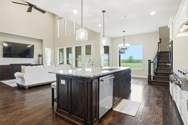 a open kitchen with stainless steel appliances granite countertop a stove a sink and a wooden floors