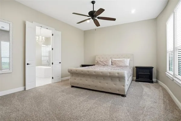 a spacious bedroom with a bed and a chandelier