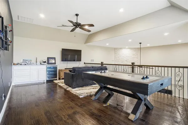 a room with stainless steel appliances lots of wooden furniture and a view of kitchen