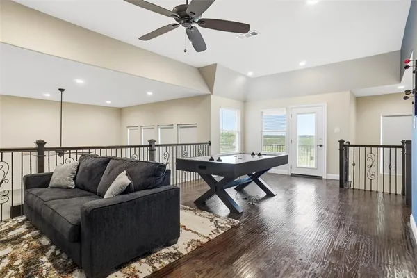 a living room with furniture wooden floor and a ceiling fan