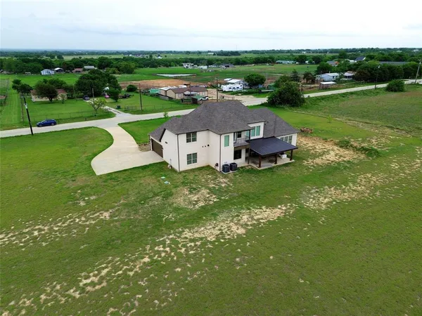 an aerial view of a house with a garden and lake view