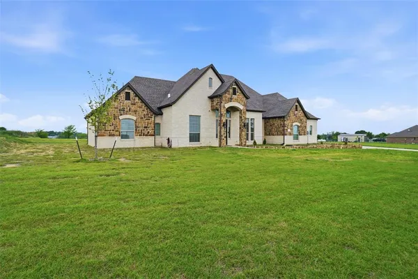 a view of a house with a big yard and large trees