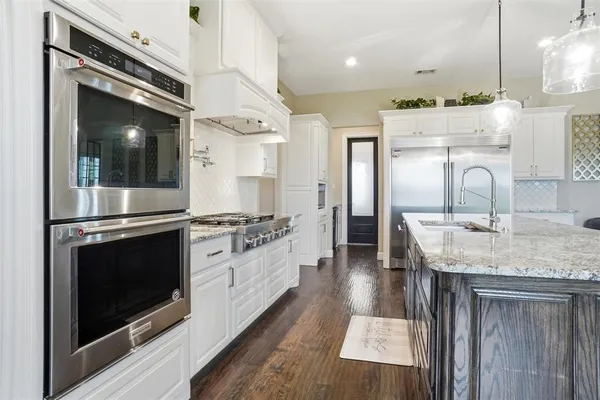a kitchen with stainless steel appliances granite countertop a stove and a sink