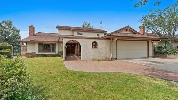 a front view of a house with a garden and yard