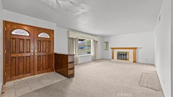 an empty room with windows cabinet and a fireplace