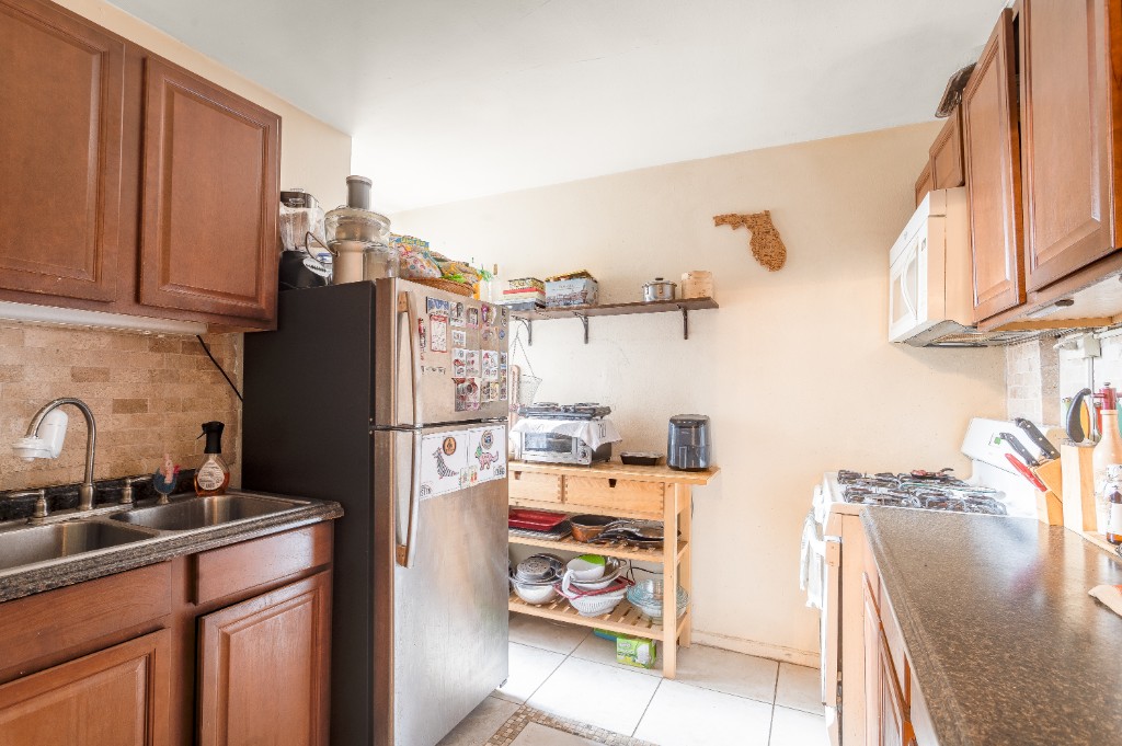 5614 Netherland Avenue, Unit 5C Bronx, NY 10471 - Photo 5 of 9 a kitchen with a refrigerator and a sink