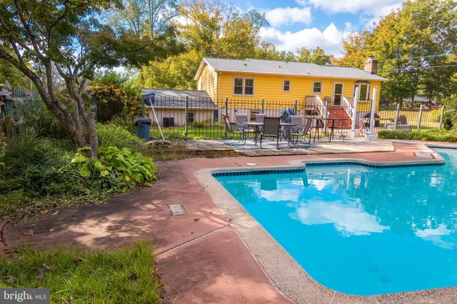 a view of a house with swimming pool and sitting area