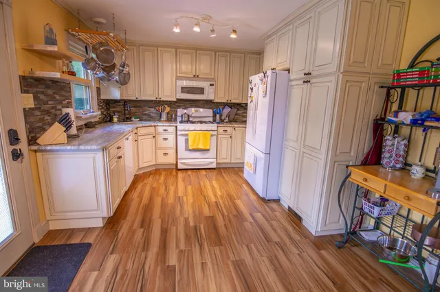 a kitchen with stainless steel appliances wooden floors and wooden cabinets