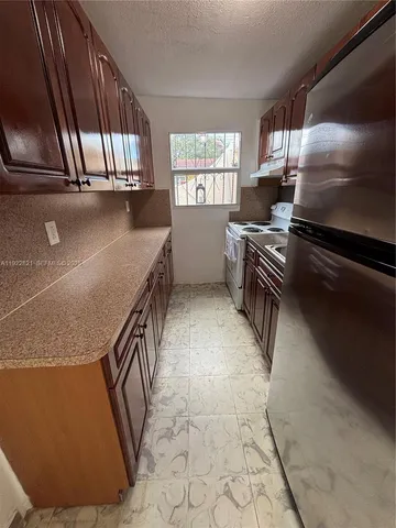 a kitchen with granite countertop a stove a sink and a microwave