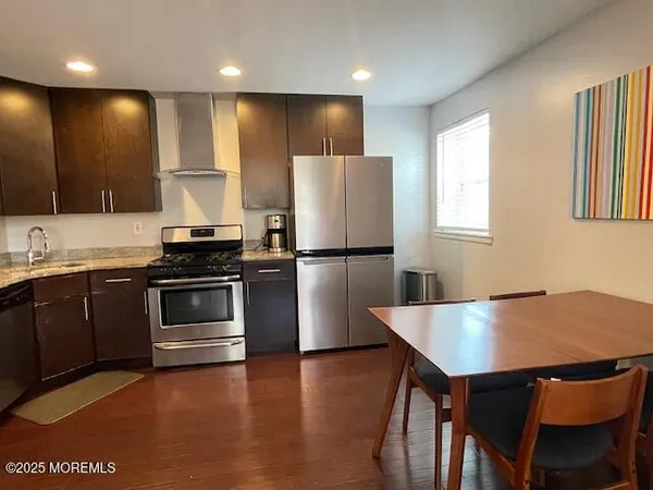a kitchen with kitchen island a stove a refrigerator and a sink