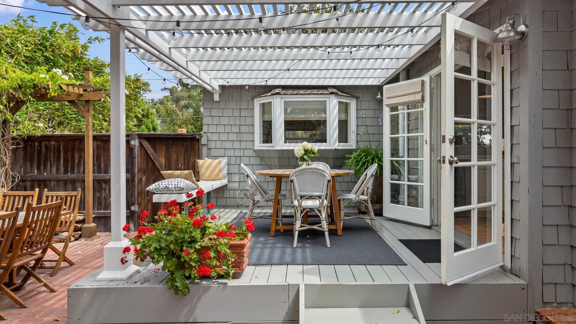 253 26th Street Del Mar, CA 92014 - Photo 19 of 21 a view of a patio with table and chairs potted plants with wooden floor and fence