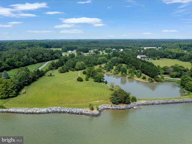 an aerial view of residential houses with outdoor space and lake view