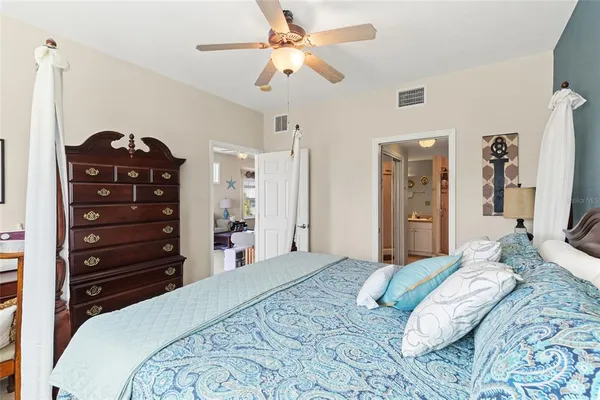 a bedroom with a bed a chandelier and a dresser