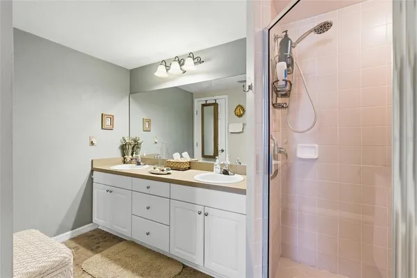 a spacious bathroom with a double vanity sink mirror and shower