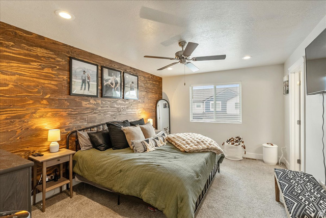287 North 100th West Morgan, UT 84050 - Photo 14 of 27 Bedroom with an accent wall, light carpet, wood walls, a textured ceiling, and recessed lighting