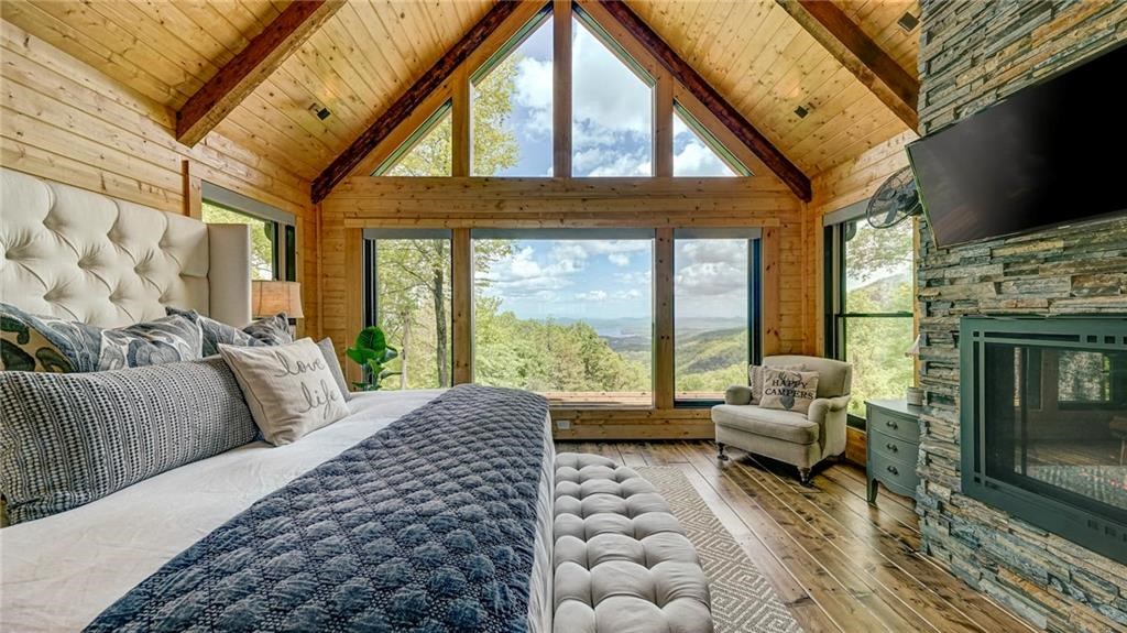 Undisclosed Address Blue Ridge, GA 30513 - Photo 22 of 51 a living room with furniture a flat screen tv and a floor to ceiling window