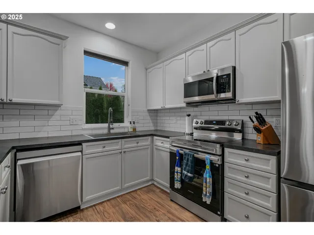 a kitchen with stainless steel appliances granite countertop a stove a microwave and a refrigerator