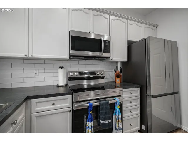 a kitchen with stainless steel appliances a stove microwave and refrigerator