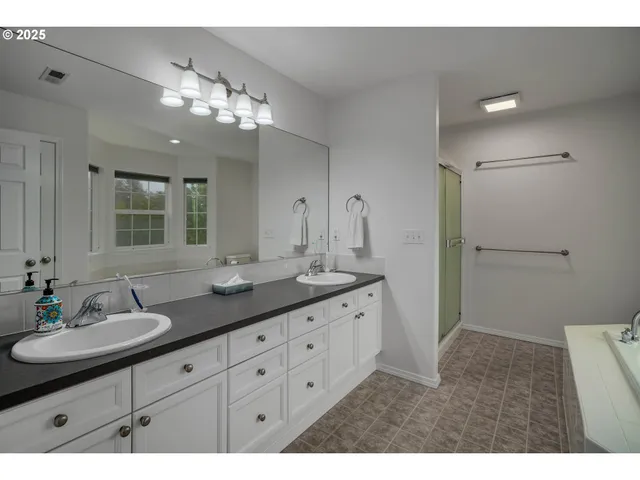 a bathroom with double sink and a mirror