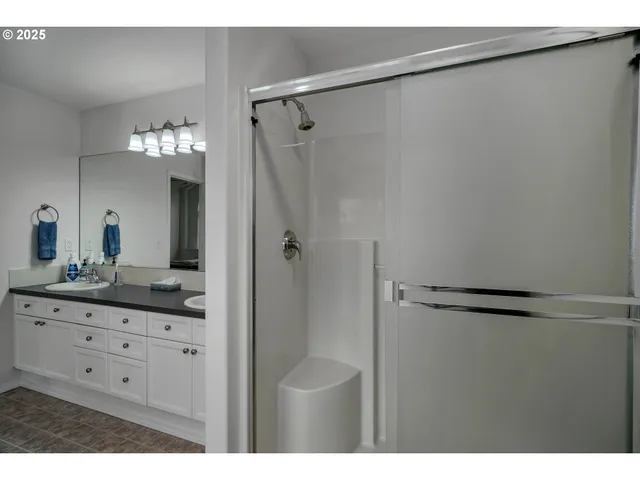 a bathroom with a granite countertop sink a mirror and a shower