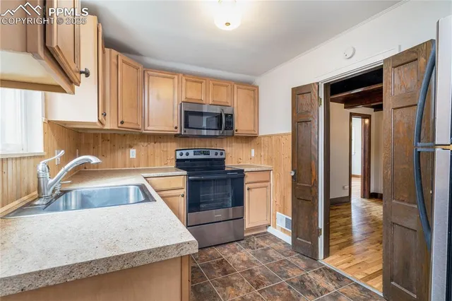 a kitchen with stainless steel appliances granite countertop a refrigerator stove and sink