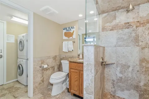 a bathroom with a granite countertop toilet a sink and a shower