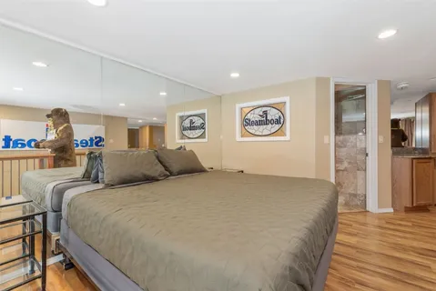 a large bedroom with a bed and wooden floor