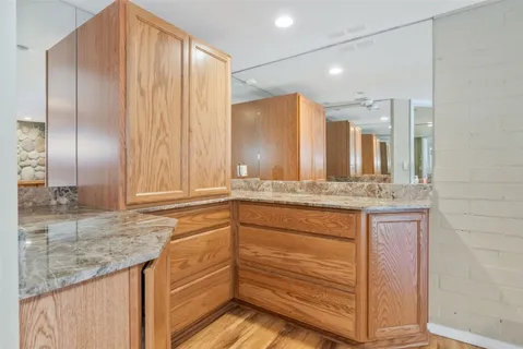 a bathroom with a granite countertop sink and a mirror