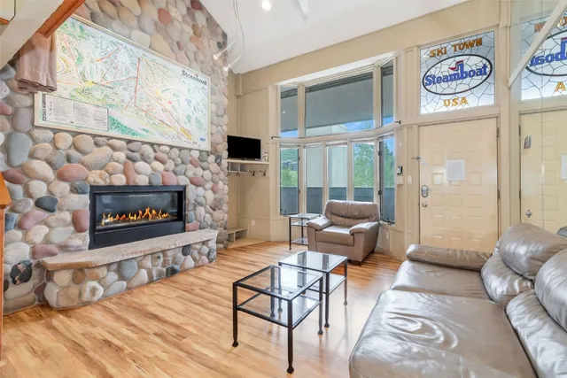 a living room with furniture a fireplace and a floor to ceiling window