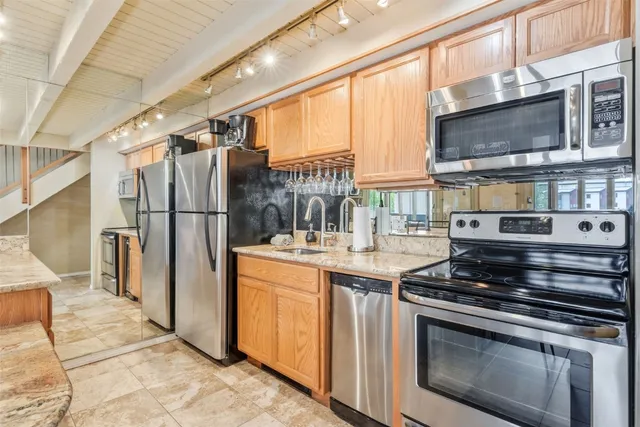 a kitchen with stainless steel appliances granite countertop a stove a refrigerator and a microwave