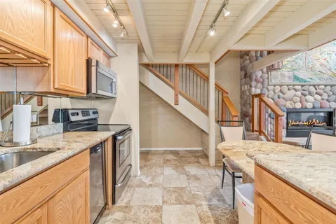 a kitchen with stainless steel appliances granite countertop a sink and a stove