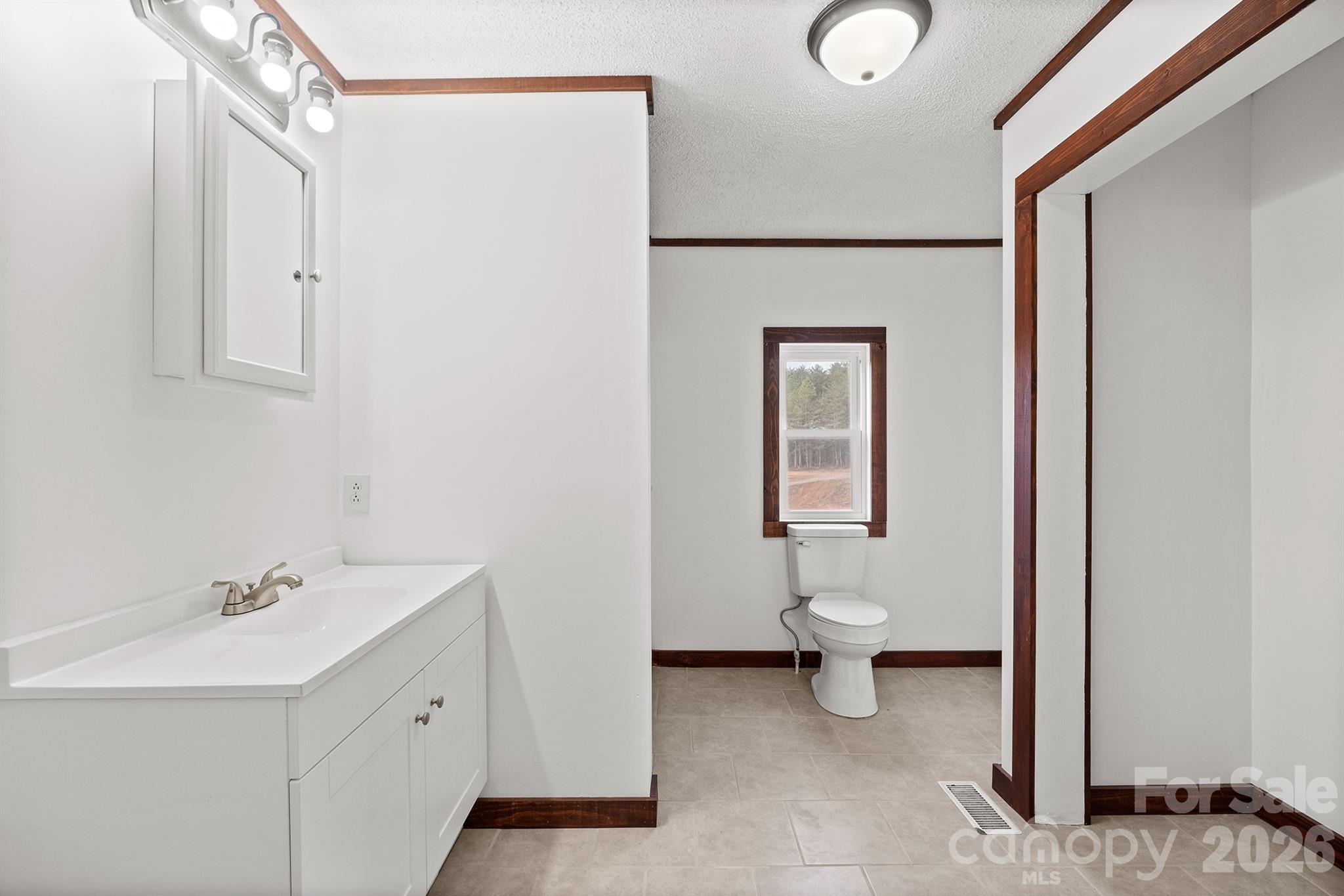 7400 Corn Hill Road Connelly Springs, NC 28612 - Photo 14 of 41 a bathroom with a toilet sink and mirror