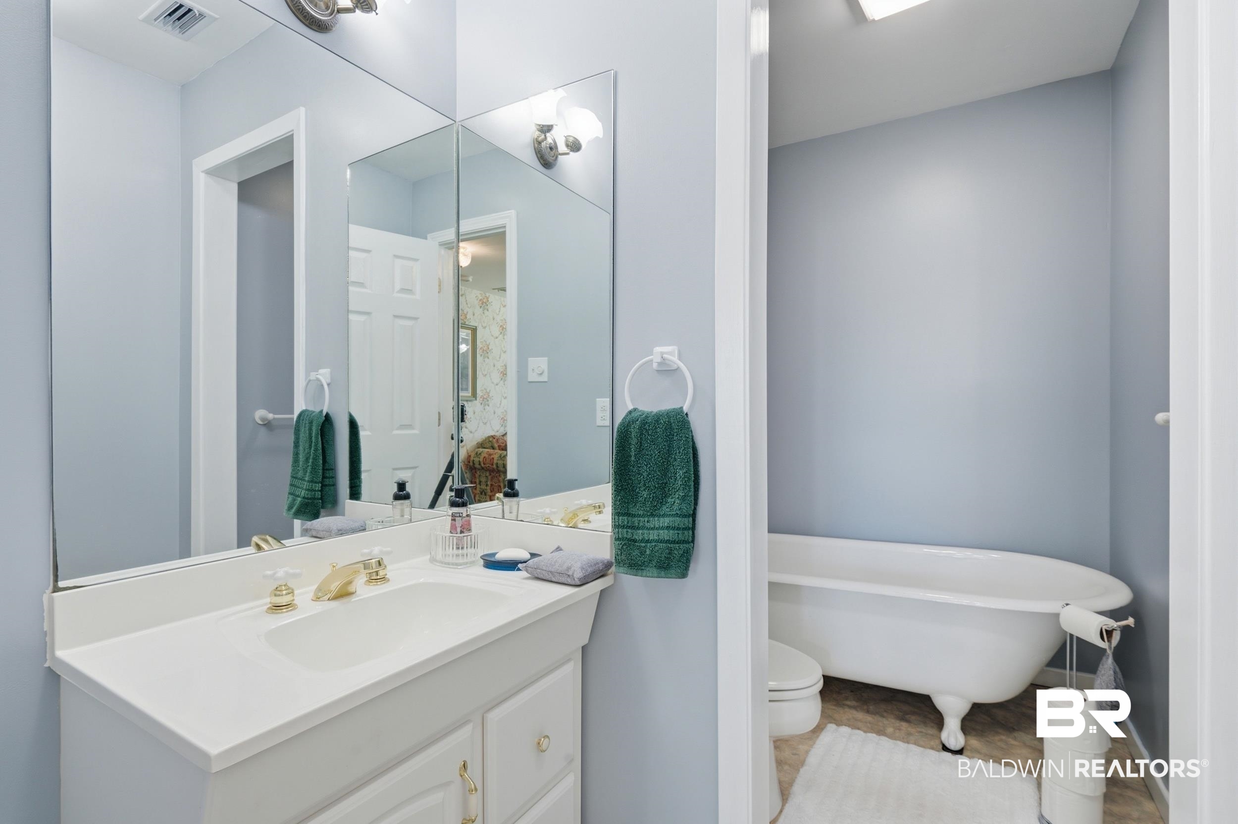 15855 Calvin Richerson Road Bay Minette, AL 36507 - Photo 48 of 83 Bathroom vanity with a white countertop and integrated sink, complemented by gold-finish fixtures