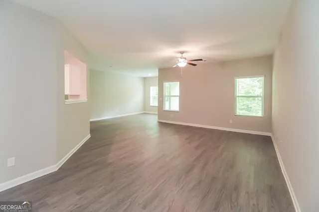 an empty room with wooden floor and window