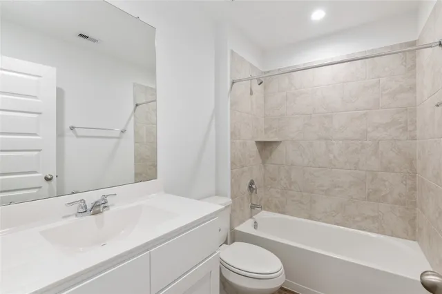 a bathroom with a bathtub shower sink vanity and toilet