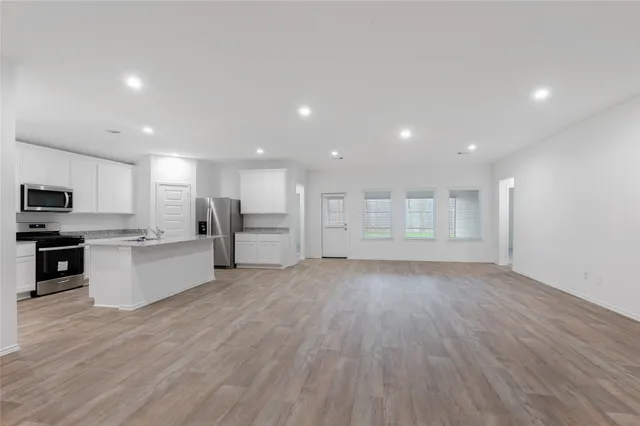 a view of kitchen with wooden floor and electronic appliances