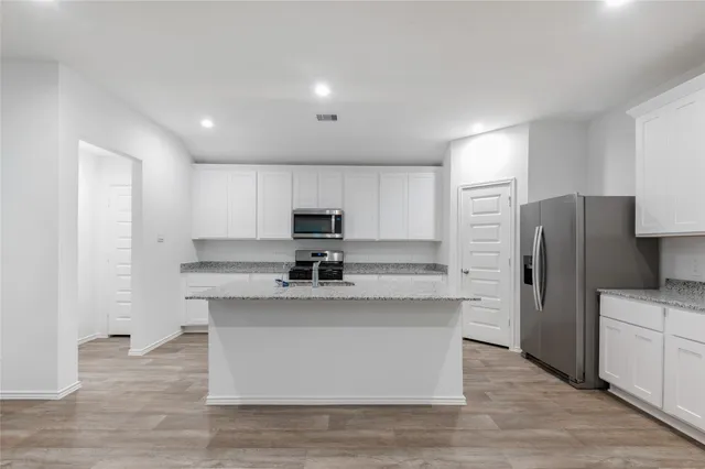 a kitchen with stainless steel appliances a sink and refrigerator